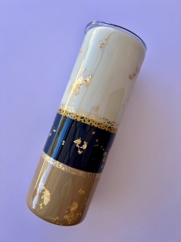 safari style 20 oz skinny tumbler gold leaf with a blue, tan and off white backdrop